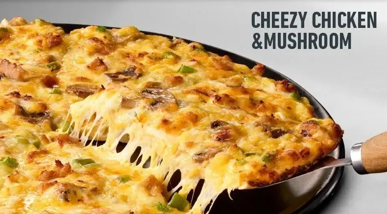 Cheesy chicken & mushroom pizza being served